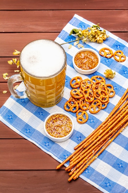 Photo oktoberfest set. light beer, pretzels, mustard, sesame straw, hop.