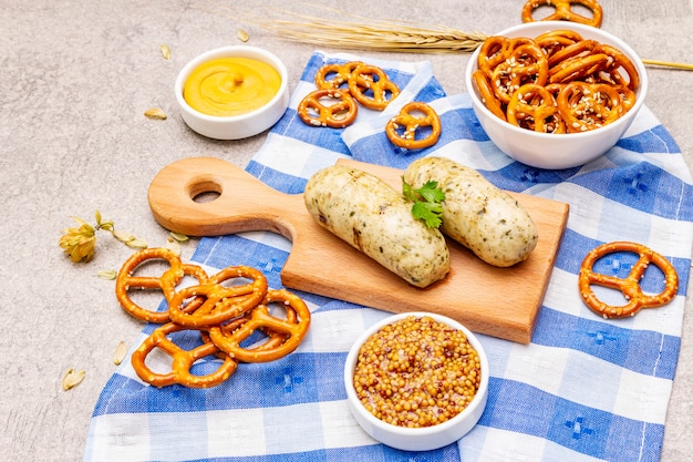 Oktoberfest set. White sausage weisswurst, pretzels, mustard, spikelets of grain, hop