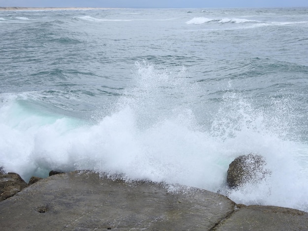 Foto olas del mar salpicando in de rotsen