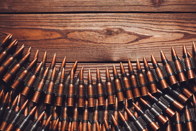 Old 7.62mm bullets on wooden table, top view