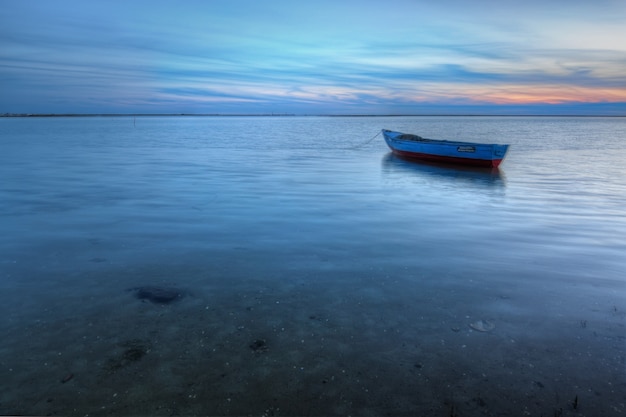 Vecchia barca abbandonata sul mare sullo sfondo di un paesaggio marino.