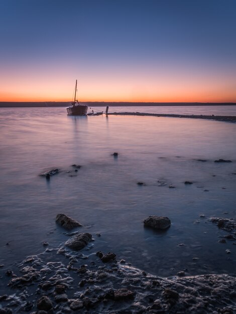 Foto vecchia barca abbandonata al tramonto