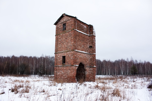 Old abandoned brick oast house in a field