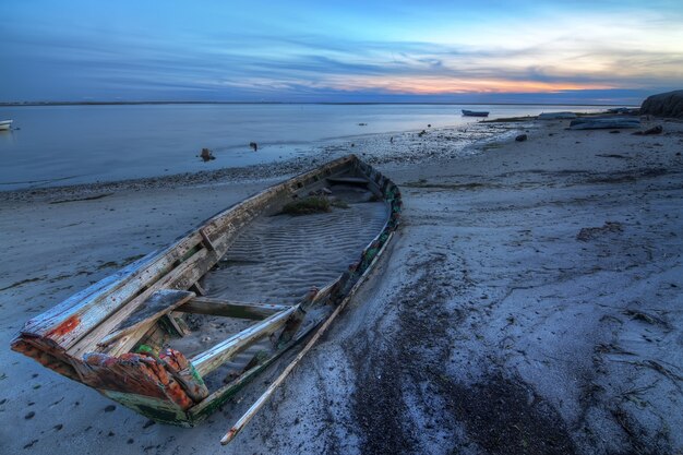 Old abandoned broken boat at sea against sea landscape.