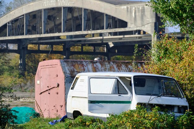 古い放棄された車の背景は,放棄され,破壊された航空ハンガーです.