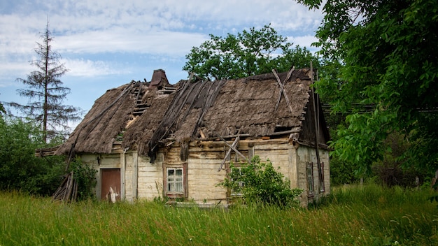 Old abandoned ruined wooden house in the countryside