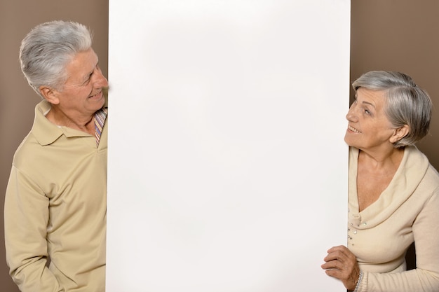 Old age couple holding blank banner and against white background