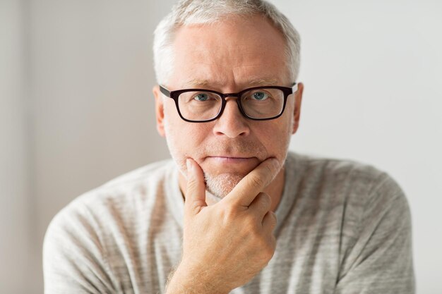 老年、問題、人々のコンセプト – 思考する眼鏡をかけた年配の男性の接写