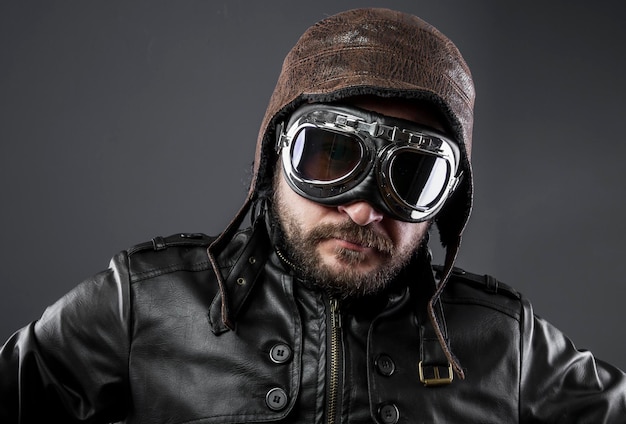 old airplane pilot with brown leather jacket, arador hat and large glasses