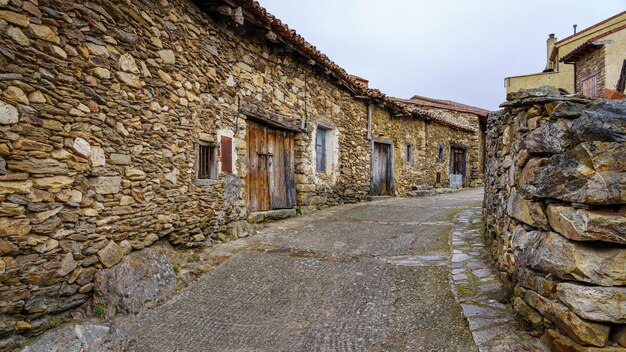 Old alley of small stone houses in a state of ruin by the passage of time. Madrid.