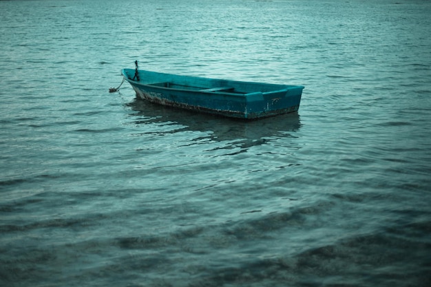 Старая одинокая лодка, плывущая по спокойной воде