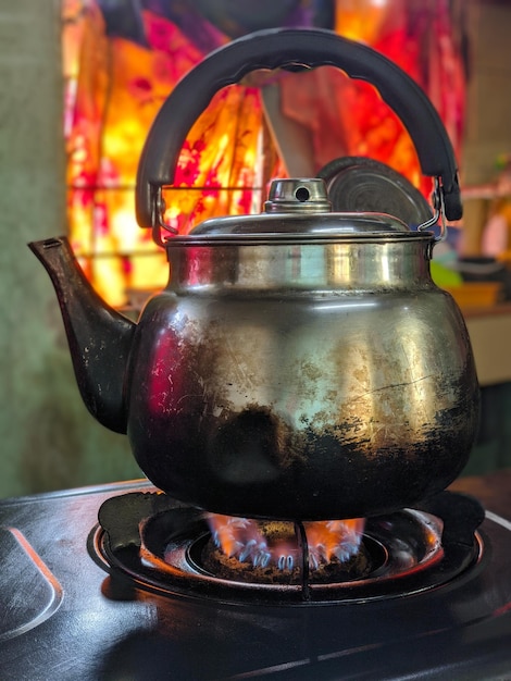 Old aluminium kettle on gas stove in the kitchen