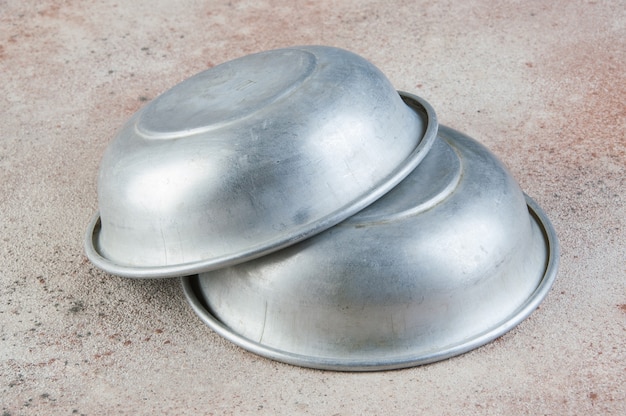 Old aluminum bowls on concrete background