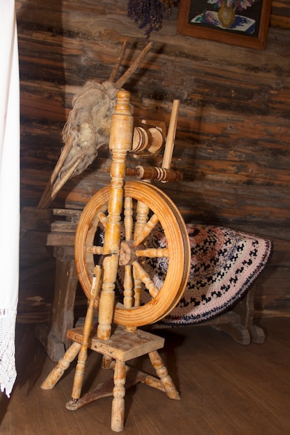 The old ancient spinning wheel stands in the hut. Fleece