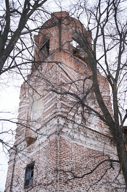 Фото Старая и разрушенная кирпичная церковь холодной зимой