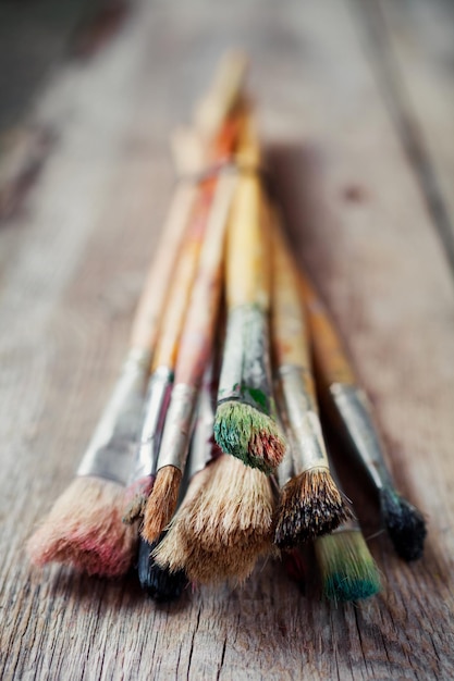 Old artist paintbrushes closeup on rustic wooden table