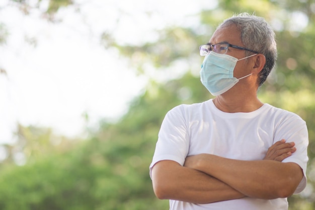 Old Asian man walking exercise outdoor and wearing medical mask