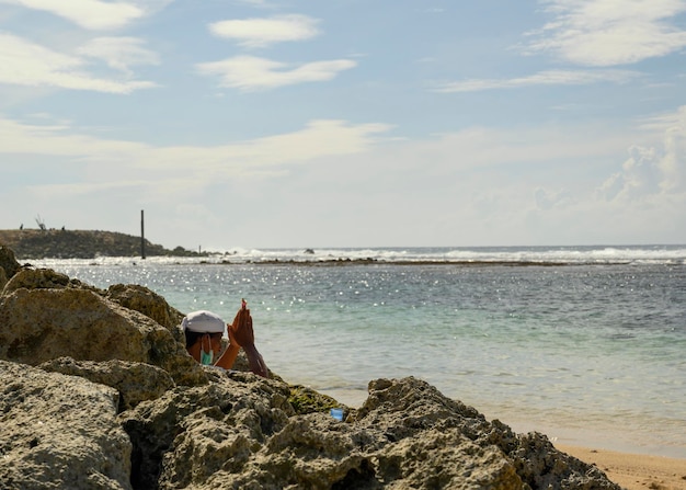 Photo an old balinese man, praying on the beach.