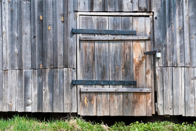 Old barn wall with locked wooden door