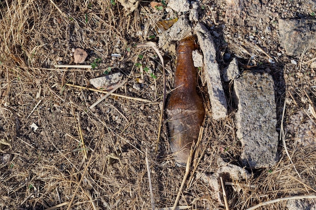 Foto vecchia bottiglia di birra gettata in campo