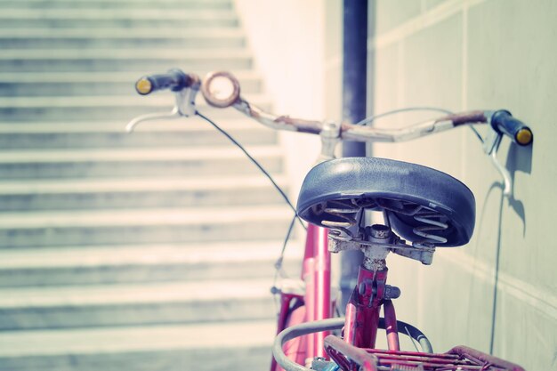 Old bicycle leaning against a wall seen from behind