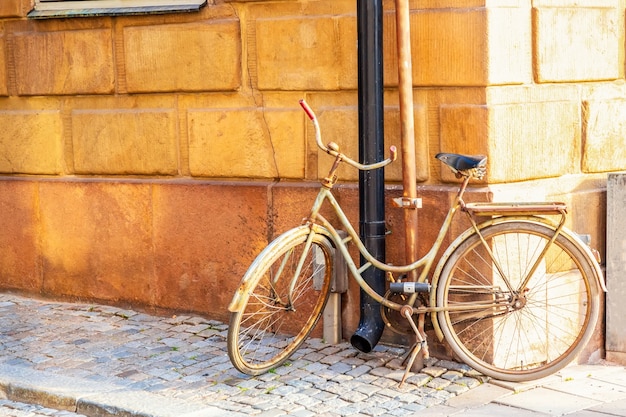 Vecchia bicicletta vicino alla casa medievale gialla di gamla stan a stoccolma