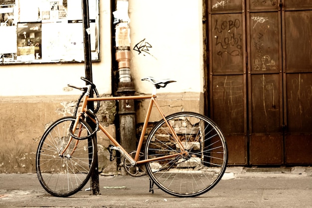 Vecchia bicicletta in piedi sulla strada della città