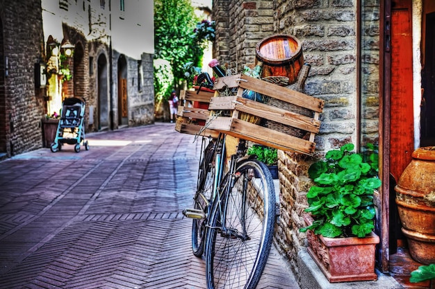이탈리아 산 지미냐노(san Gimignano)의 벽돌 벽에 나무 케이스가 있는 오래된 자전거