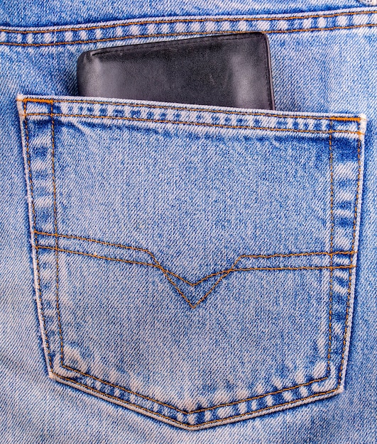 청바지 뒷 주머니에 보여주는 오래 된 검은 지갑