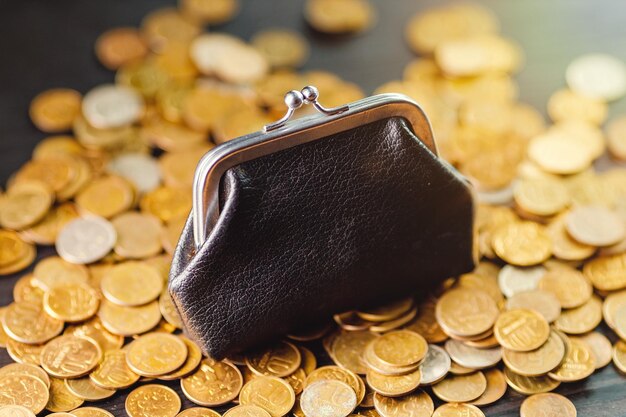 Photo an old black wallet sits on top of a pile of yellow russian coins the concept of inflation and poverty