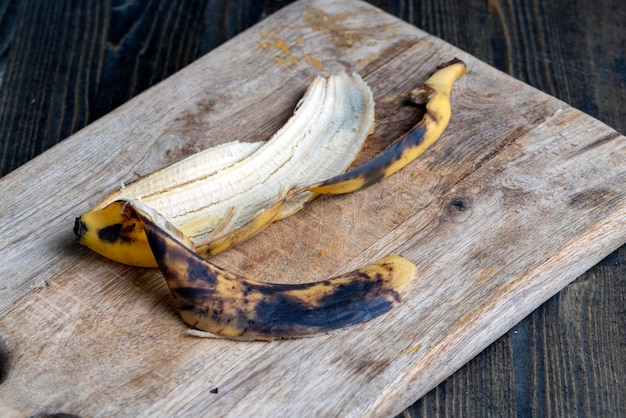 Old blackening banana on a cutting board perishable banana fruit food