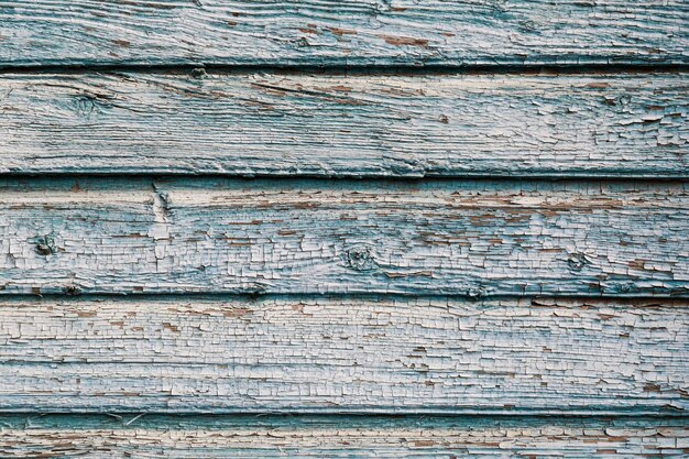 Old blue cracked paint on the old wooden background