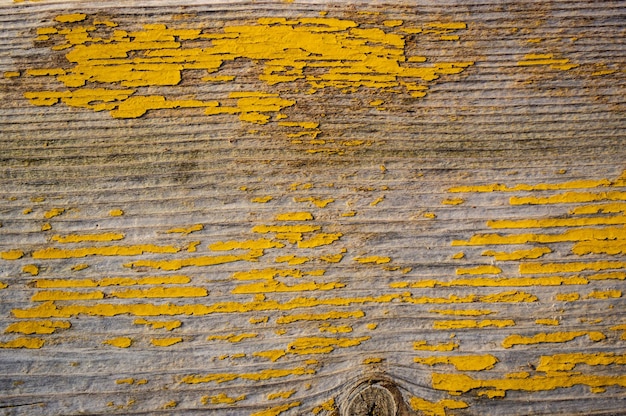 Old board with the remains of yellow paint