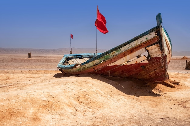 An old boat stands alone in the middle of a salt desert