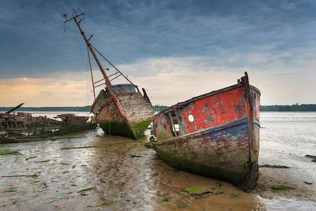 Photo old boat wrecks under a stormy sky