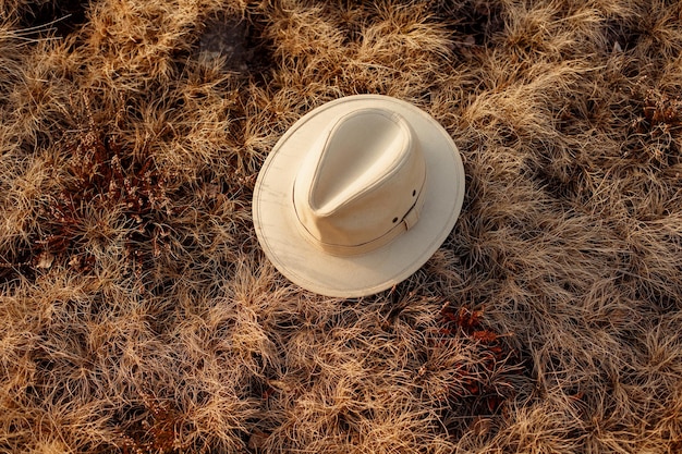 Old boho or cowboy hat on grass at sunset in mountains travel concept space for text