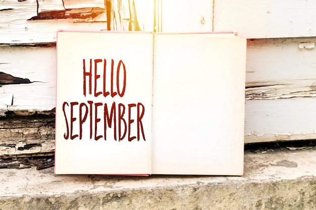 old book with hello September above wall and near to grunge wooden