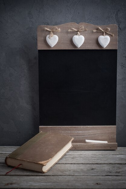 Old book and wooden blackboard