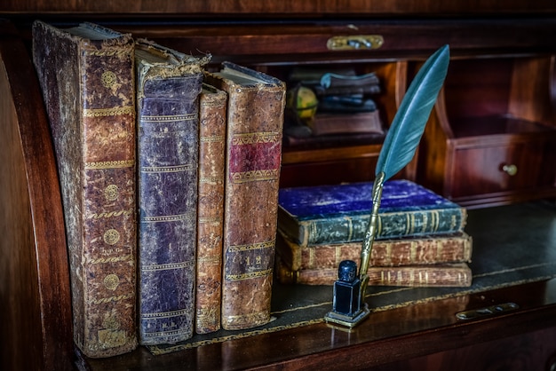 Old books on desk and pen writing