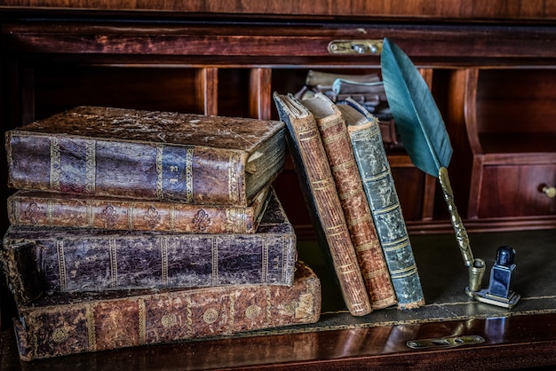 Old books on desk and pen writing