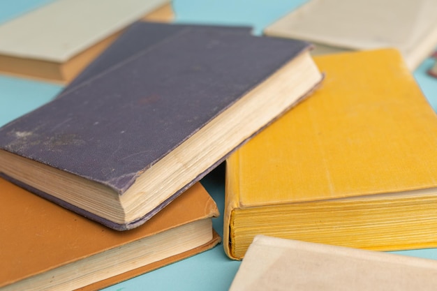 Old books on light blue table World Book Day background