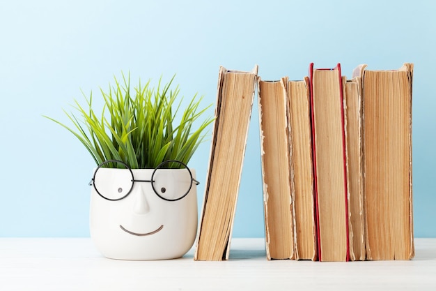 Old books and potted plant with eyeglasses