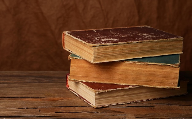 Старые книги на столе на коричневом фоне