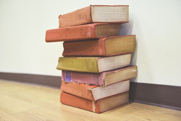 Old books on a wooden floor Book stack in the library room for business and education