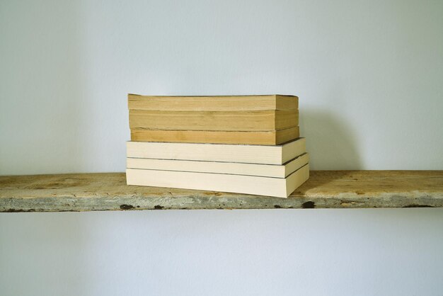 Old books on a wooden shelf.