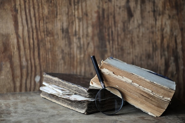 Foto vecchi libri su un tavolo di legno e lente d'ingrandimento in vetro