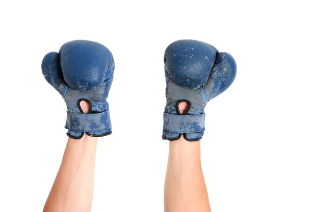 Old Boxing gloves are worn on the hands, on a white background.