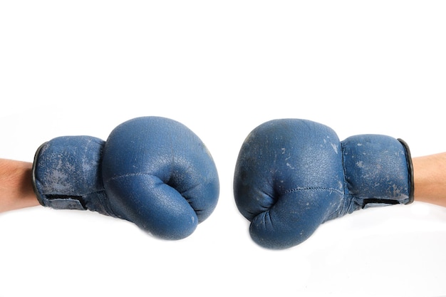 I vecchi guantoni da boxe sono indossati sulle mani, su uno sfondo bianco.