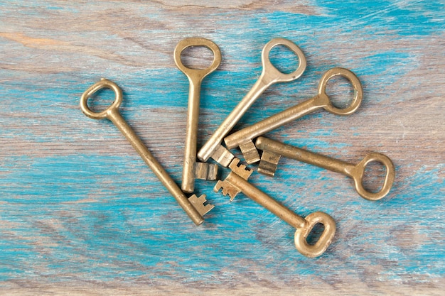 오래된 황동 열쇠, 나무 배경에 있는 고전적인 금속 열쇠의 세부 사항. 텍스트를 위한 공간 복사`