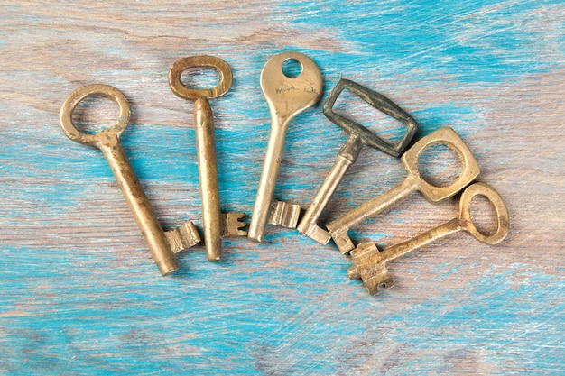 Old brass keys, detail of a classic metal keys on wooden background. Copy space for text